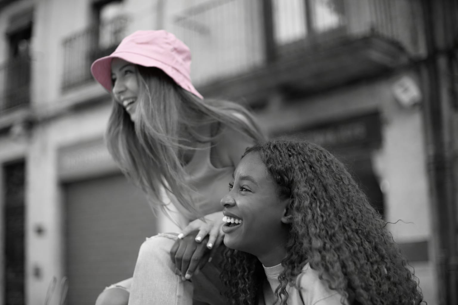 Two friends laughing together on a city street