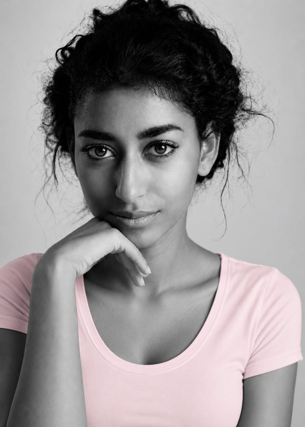 A girl in a pink t-shirt looking directly at the camera